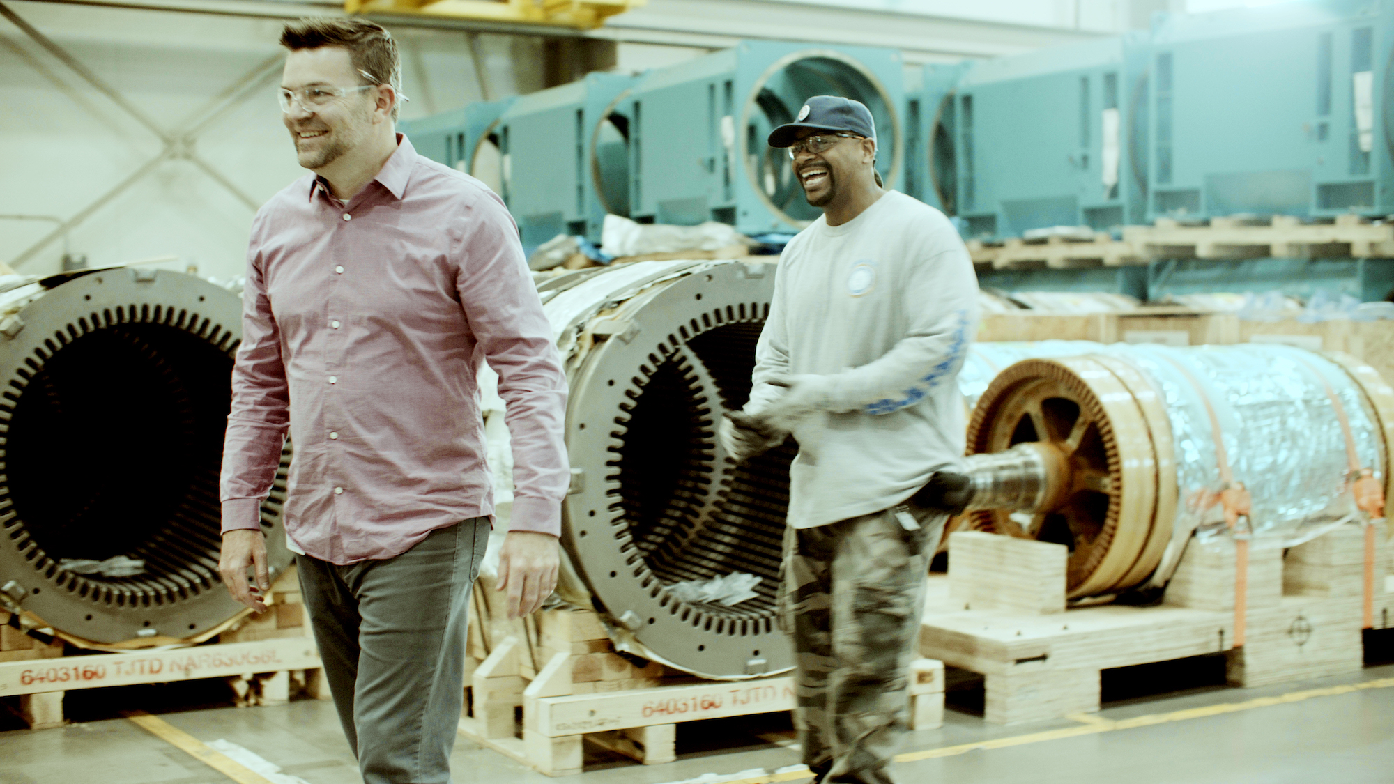 AK at work, laughing alongside another man.
