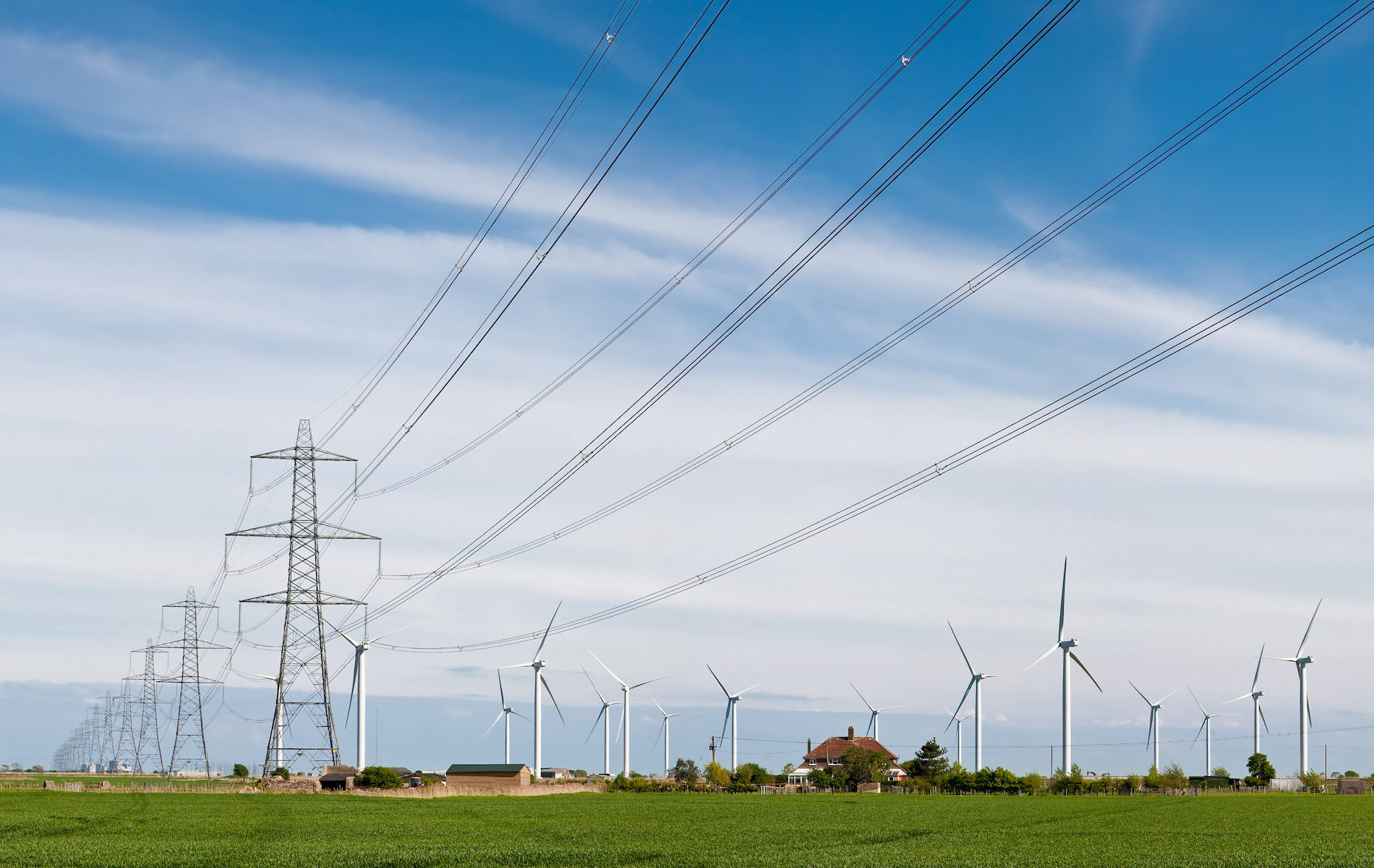 Wind turbines in a field near power transmission lines. 