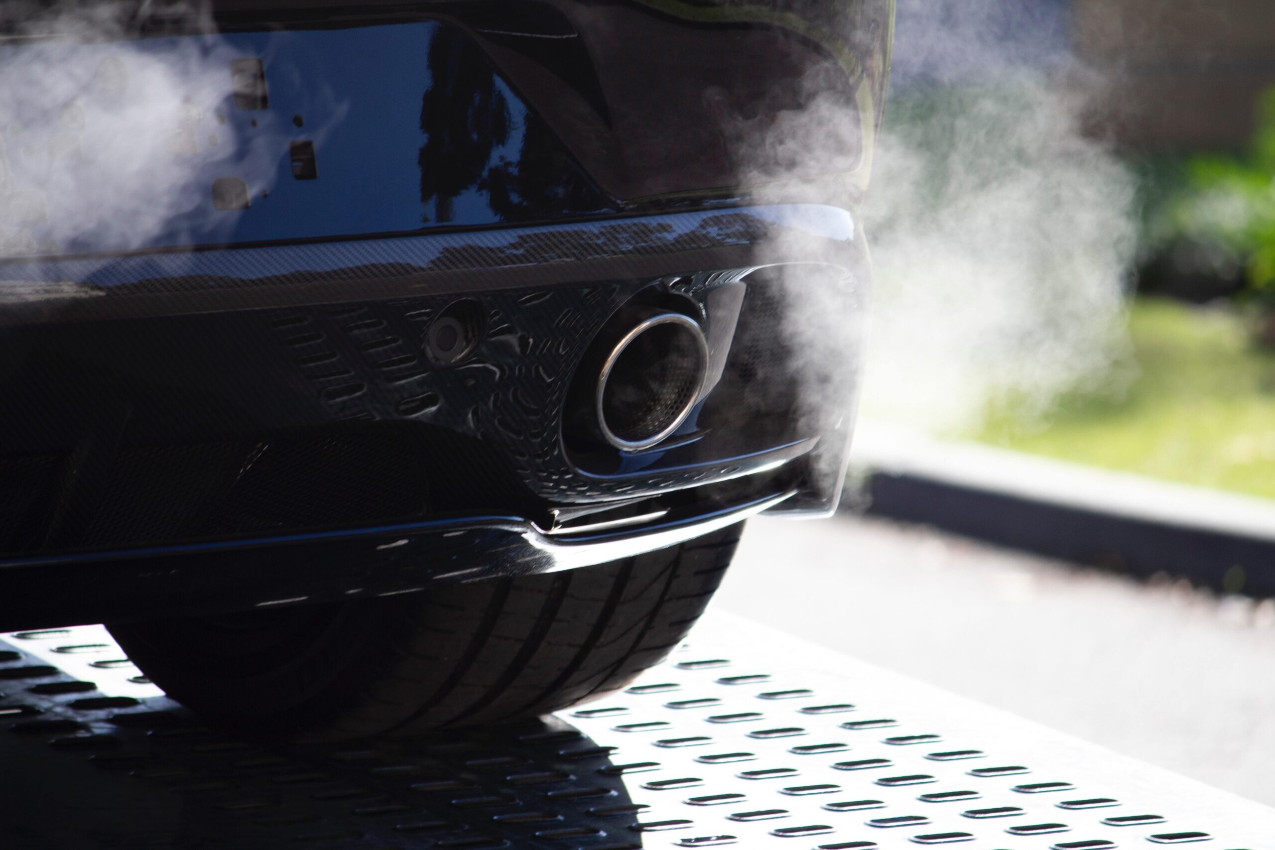 A car emitting exhaust through its tailpipe. 