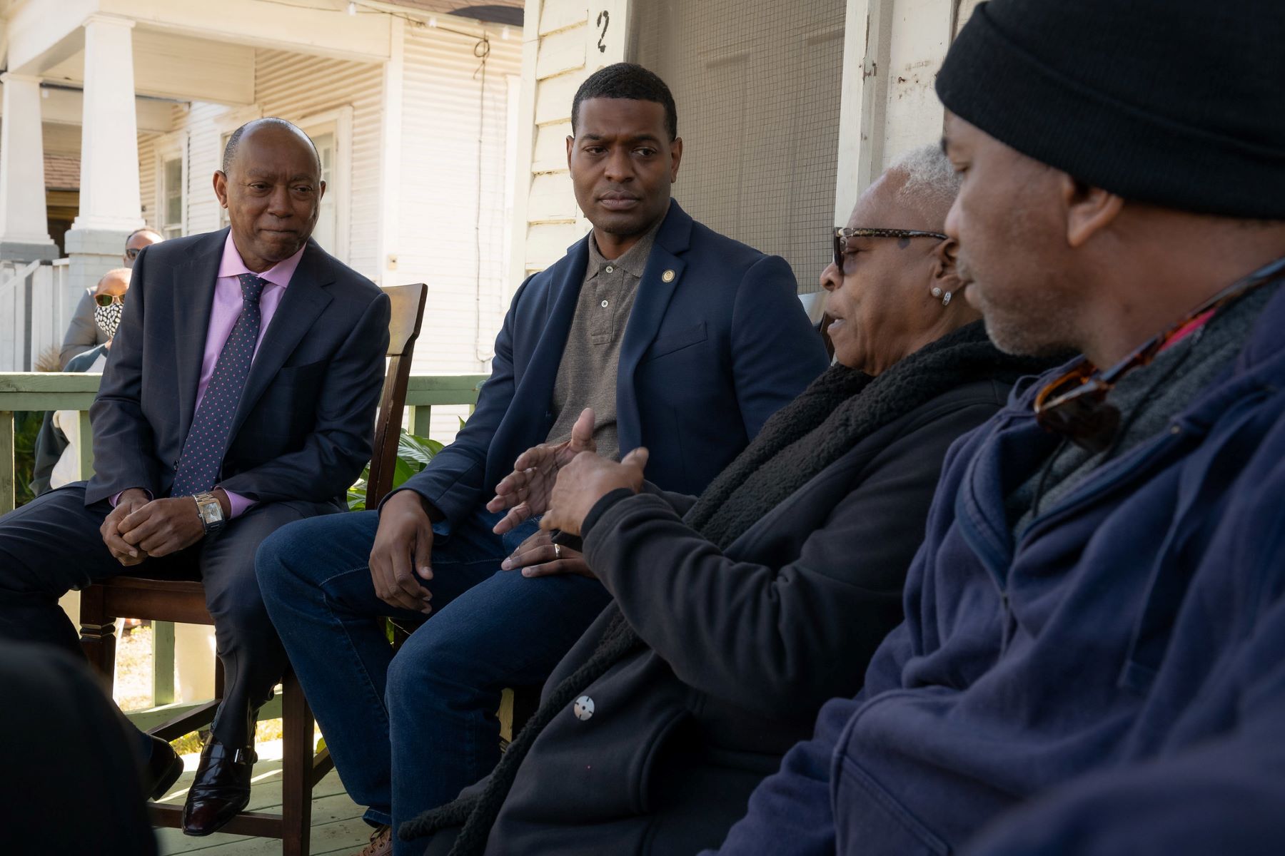 EPA administrator Regan listening to community members impacted by air pollution, on a porch in Texas.
