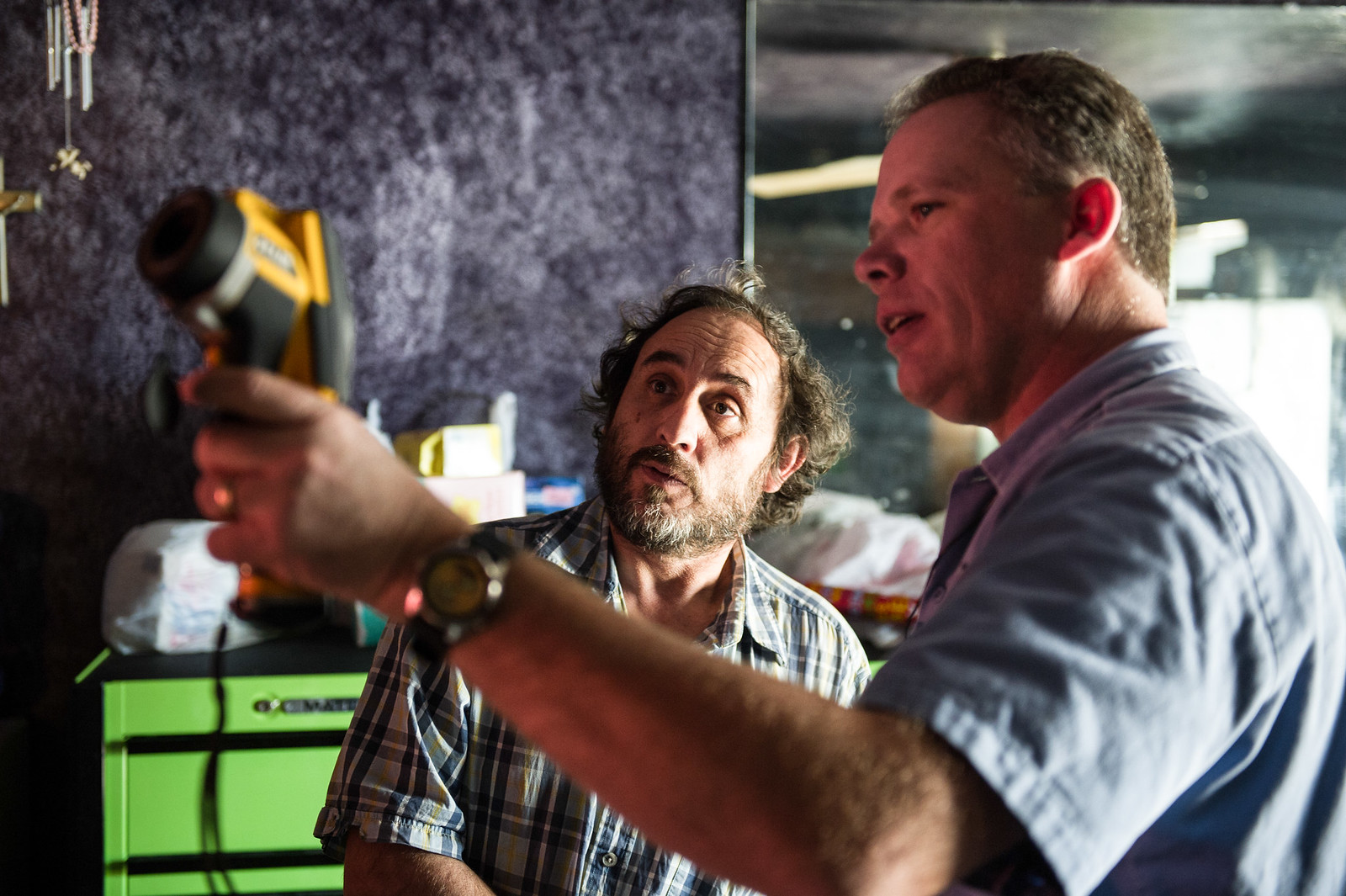 A home energy efficiency auditor shows a Colorado resident how much heat is lost through his windows using an infared hand tool.