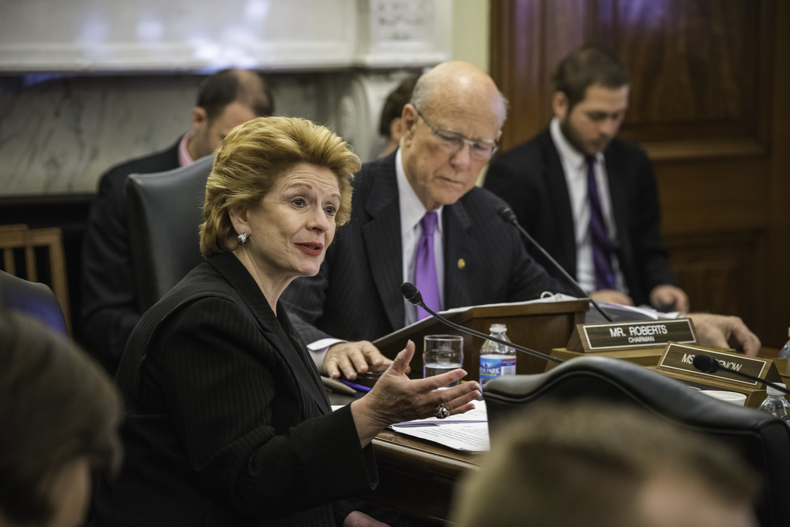 Senator Debbie Stabenow speaking to fellow congresspeople on her right, at a meeting.