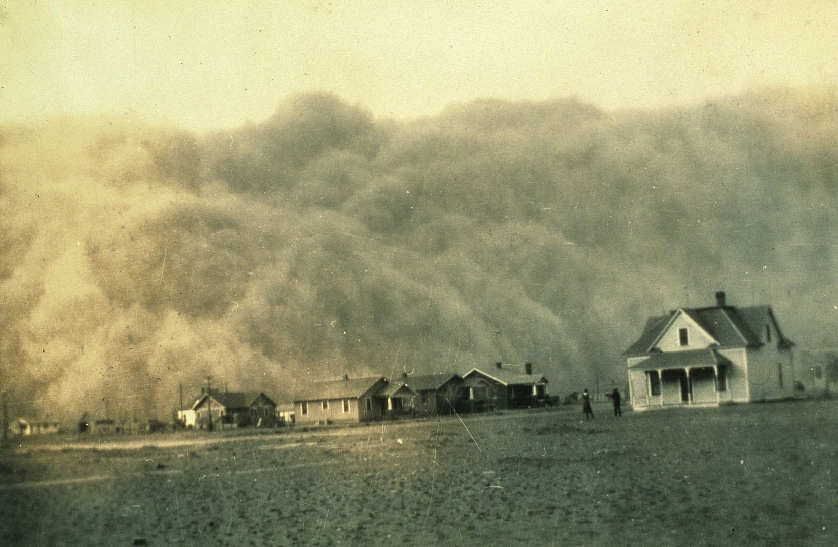 A dust storm engulfing small farming houses in the 1930s.