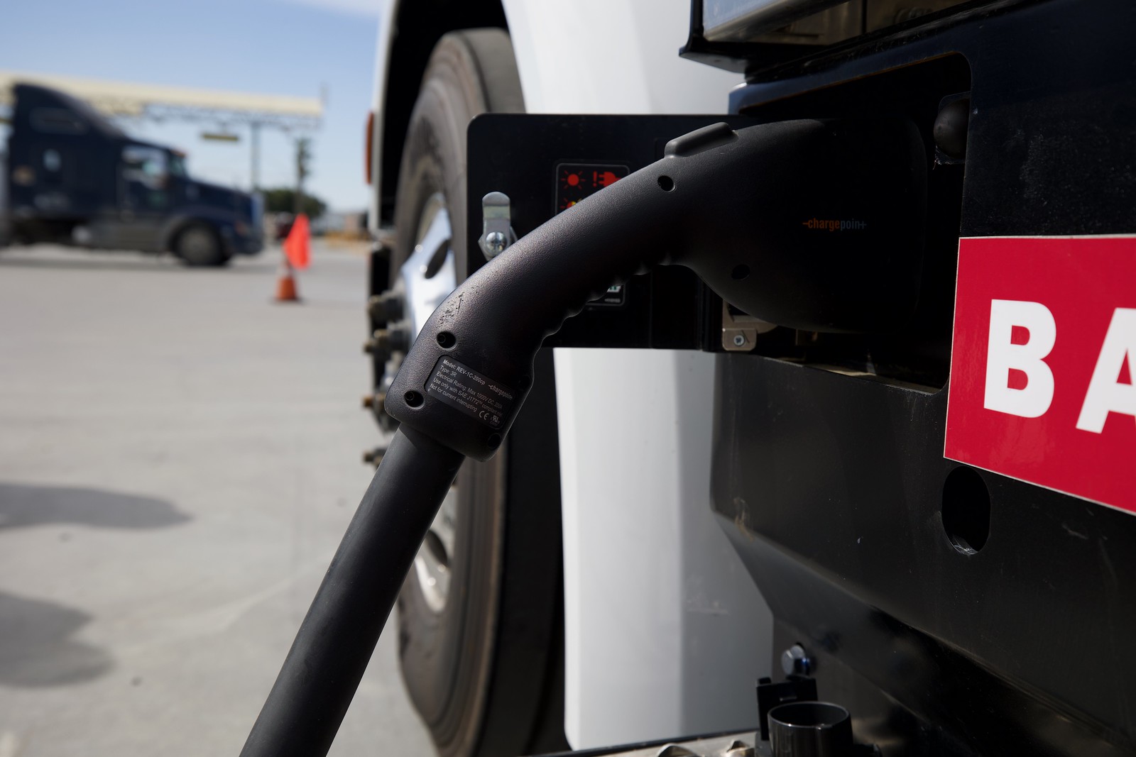 Close up a charger plugged into an electric truck.