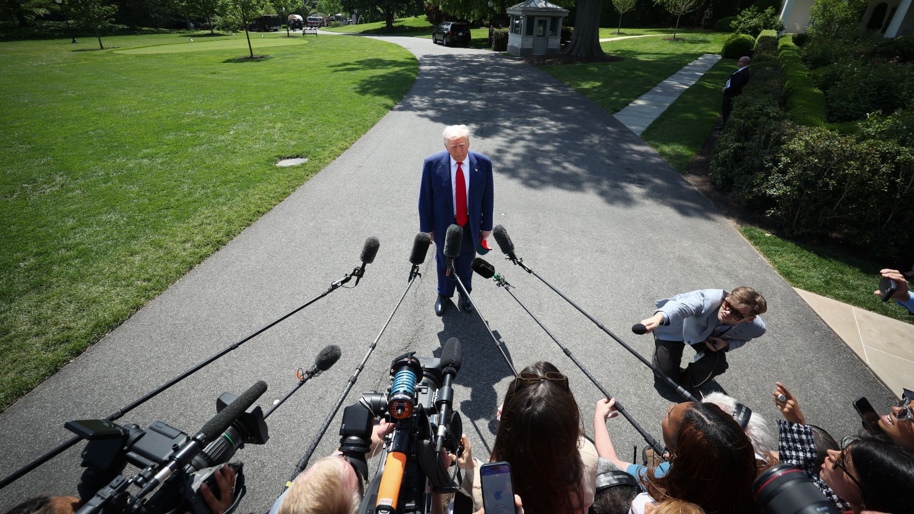 Overhead view of President Trump with many reporters' microphones pointed at him