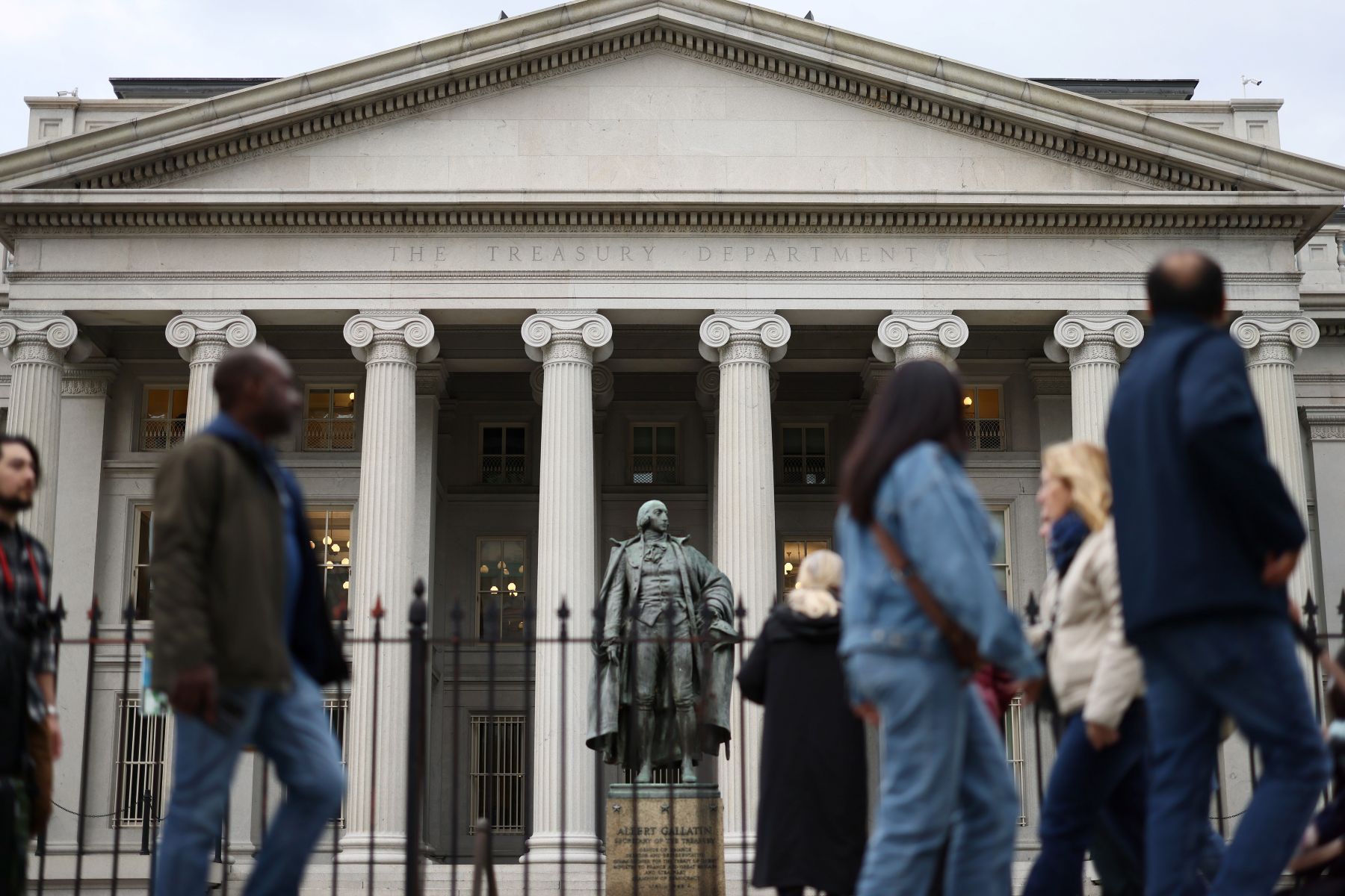 Pedestrians walking by the U.S. Treasury Department building